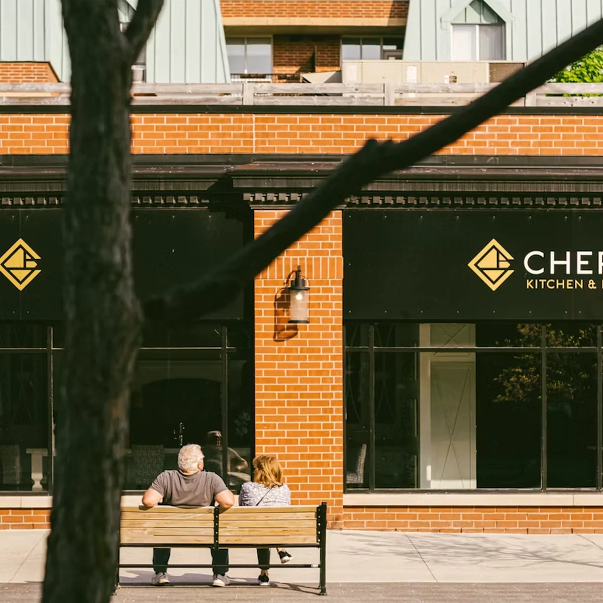 Pedestrian sitting outside a brick commercial building in Oakville