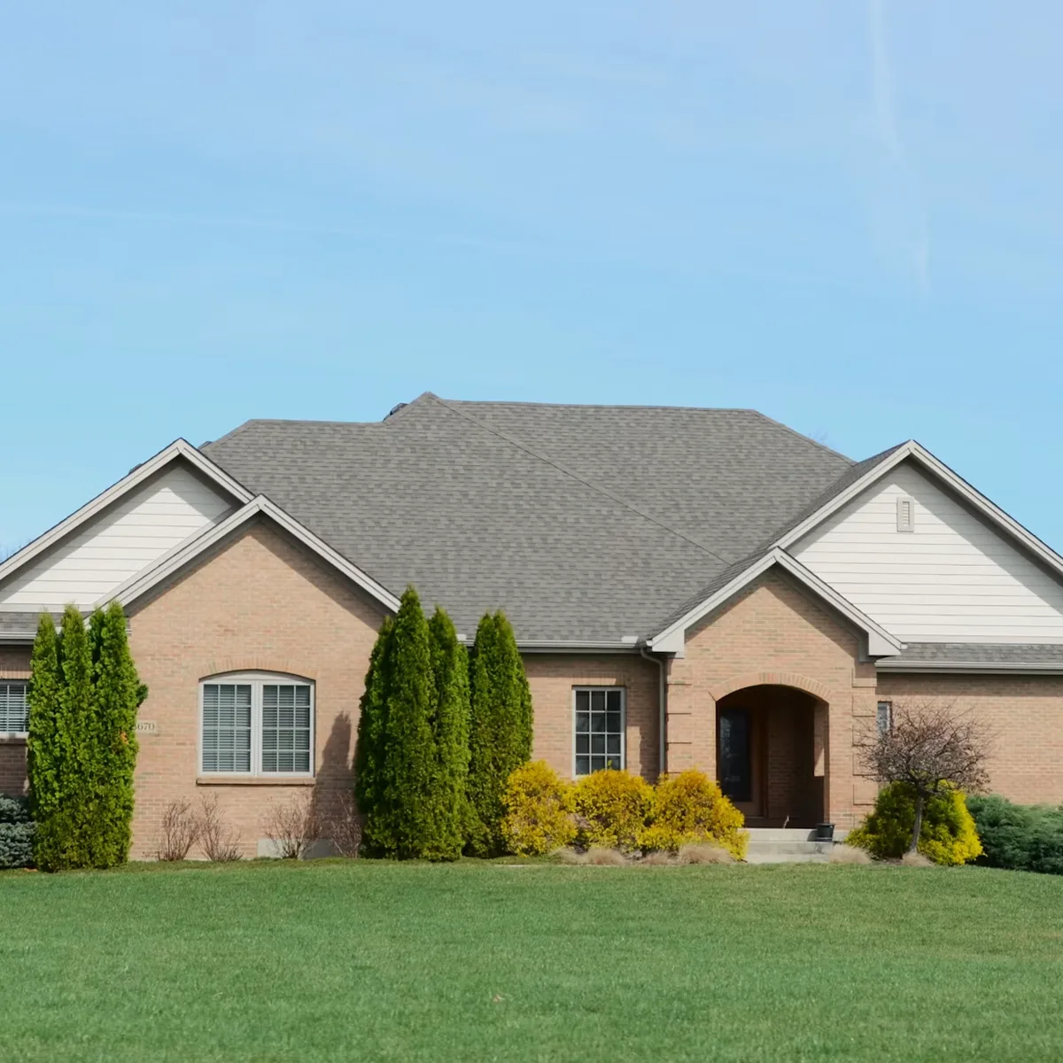 Detached brick home with landscaped front lawn